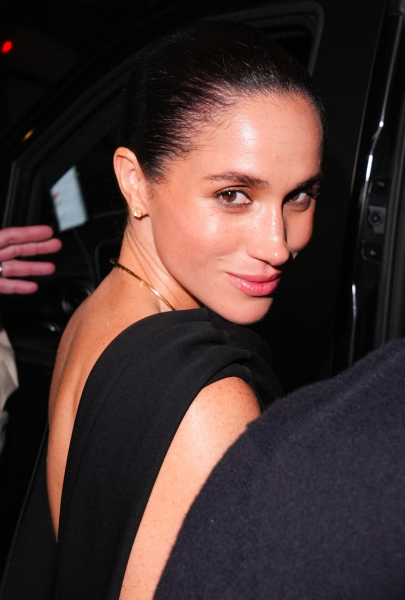 Megan Markle looks over her shoulder in black dress